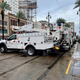 White electrical utility trucks sit on a street in New Orleans, Louisiana